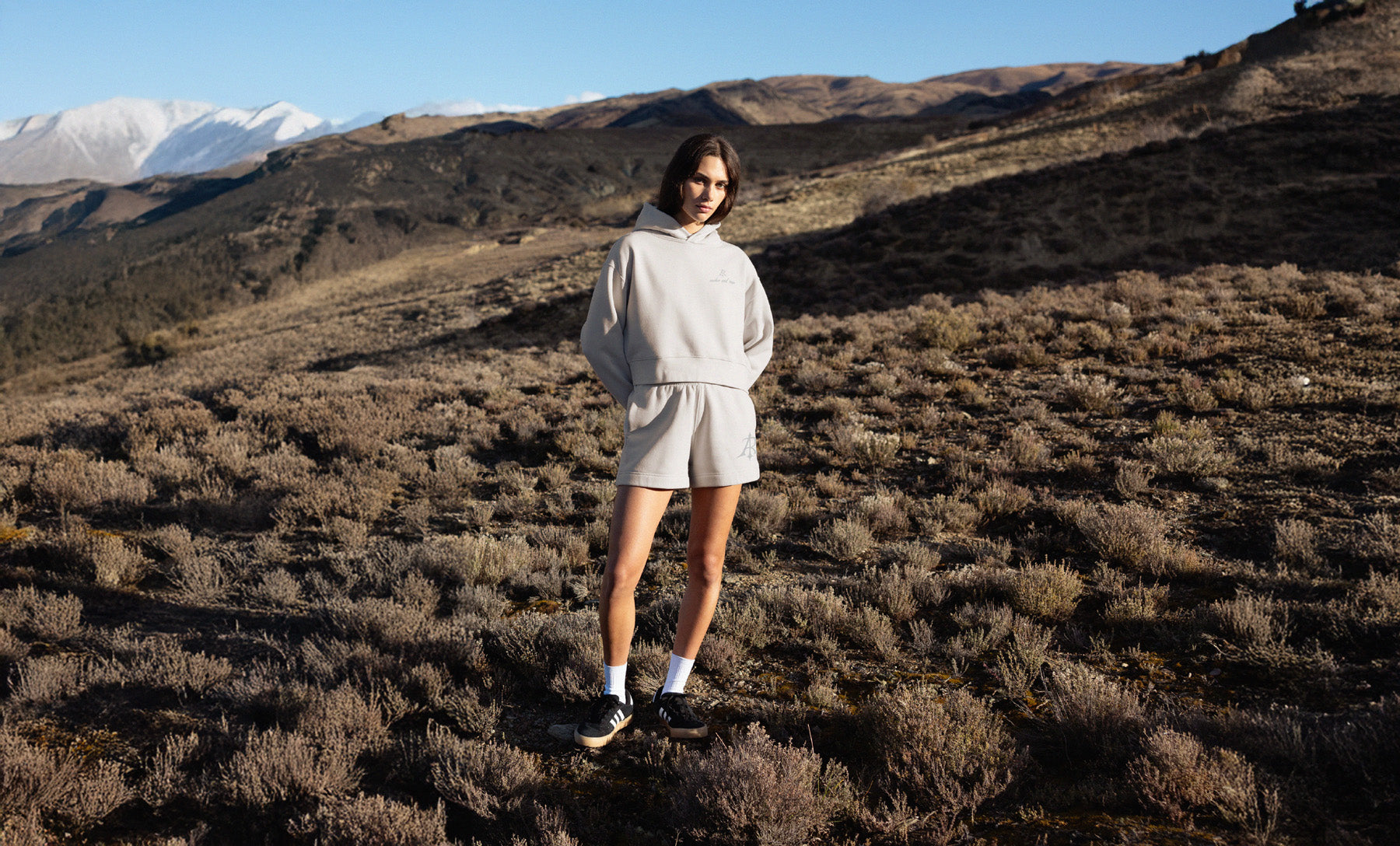 Women standing in a desert landscape with mountains in the background
